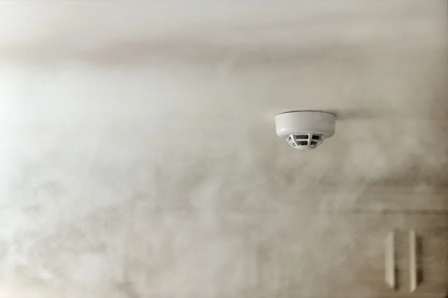 Vivint's Smoke & CO Detector alerts you instantly whenever smoke, rising heat, or CO is detected. Vivint's Smoke & CO Detector attached to a ceiling and surrounded by smoke.